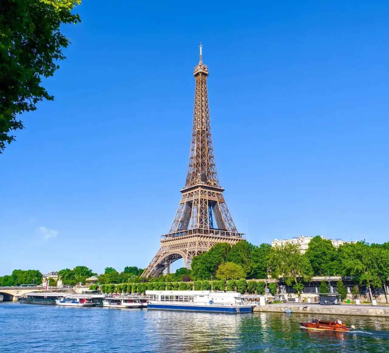 The complete Eiffel Tower in daylight above its riverbank setting, Paris
