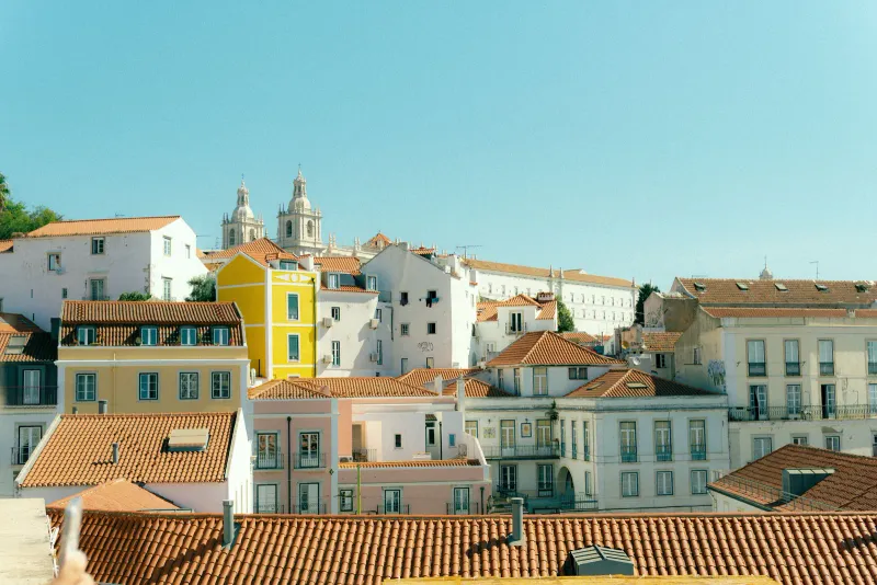 Sunlit pastel buildings and tiled rooftops in Lisbon