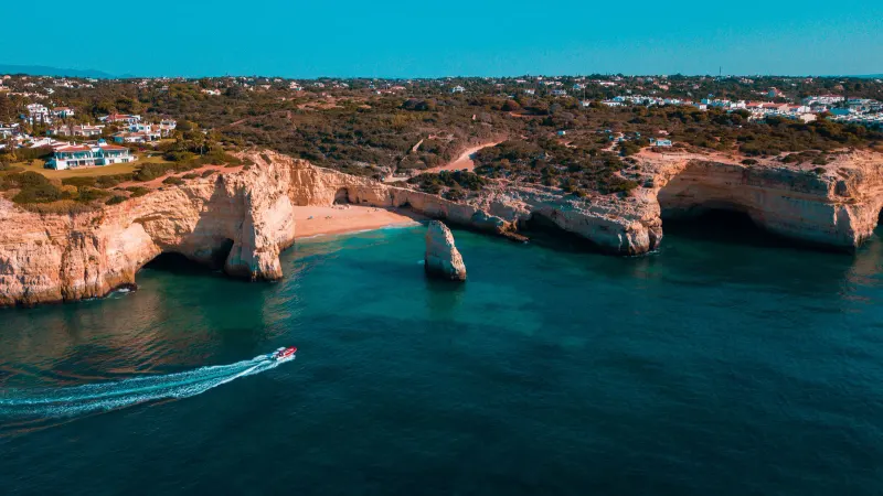 Golden limestone cliffs and blue-green water on the Algarve coast at Lagoa