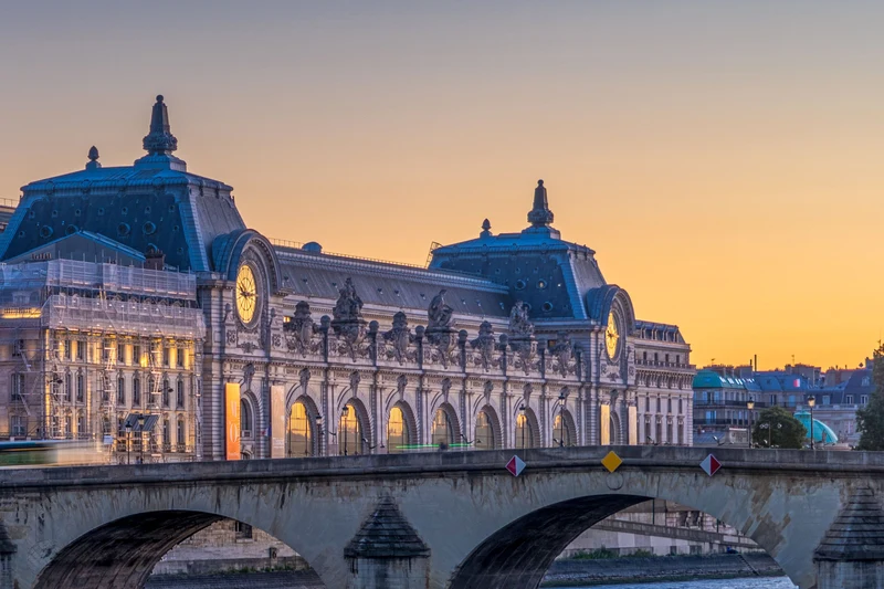 Musée d’Orsay’s clock façade and Pont Royal at dusk, Paris; riverside context