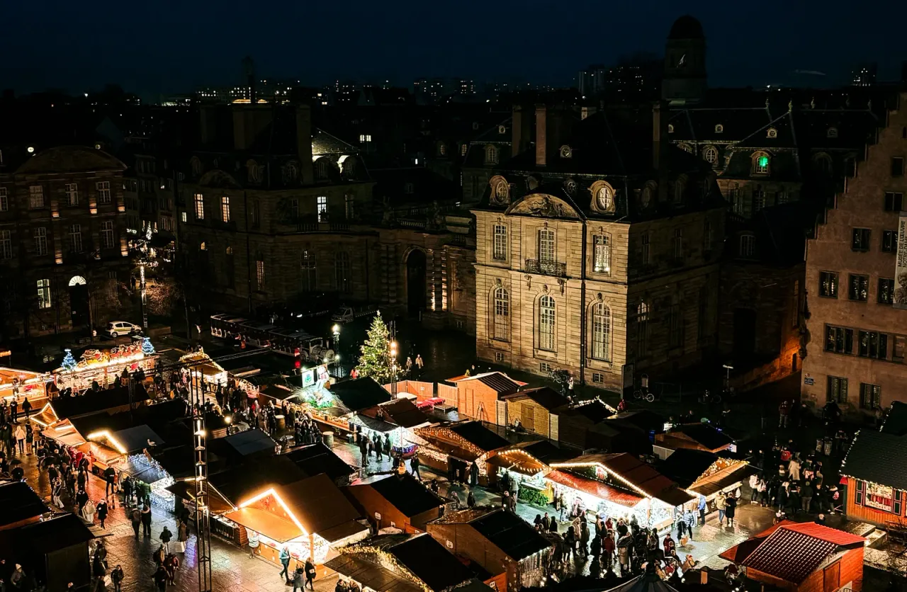 An elevated view of illuminated market roofs and historic buildings in Strasbourg.
